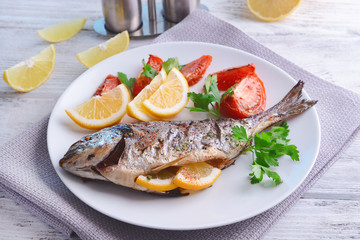 Tasty baked fish on table close-up