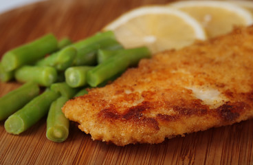 Breaded fried fillet and potatoes with asparagus and sliced