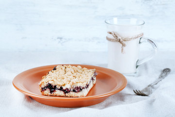 Homemade grated pie with jam and glass of milk