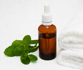 Bottle of mint oil and fresh mint