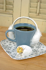ear muffs on cup of coffee with donut