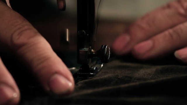 Close up shot of a tailors hands sewing a dress