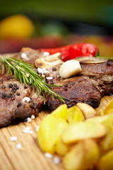 T-bone steak on the barbecue grill with vegetable spears in the