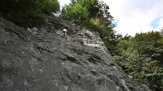 HD1080p: Man rock climbing in nature shot from below