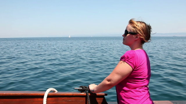 Shot of the young woman on a boat looking at the sea