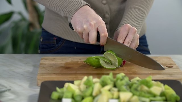 Woman cuts the lime into pieces