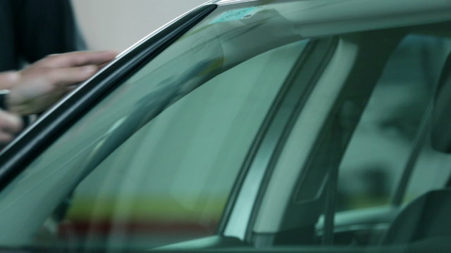Man knocking to check if the windshield is fixed