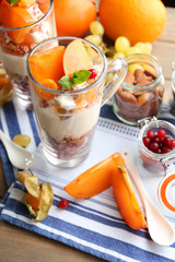 Healthy layered dessert with muesli and fruits on table