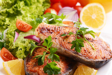 Tasty baked fish on plate close-up