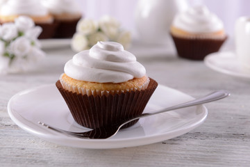 Delicious cupcakes on table on light background