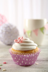 Delicious cupcake on table on light background