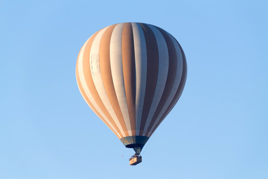 A hot air balloon flying on a clear sky day.