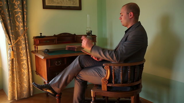 Businessman reading a book in an old fahioned room