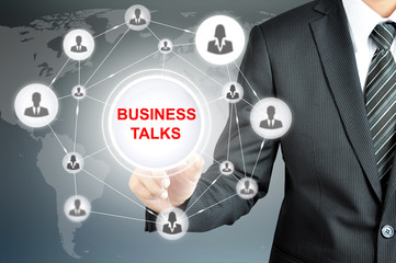 Businessman pointing on BUSINESS TALKS sign on virtual screen 