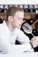 man smelling a white wineglass