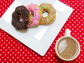 donut and milk coffee on red tablecloth