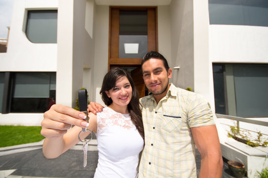 happy couple holding key to their new house