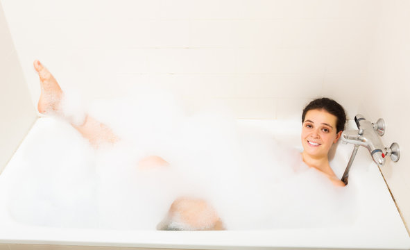  young girl laying with foam in bath