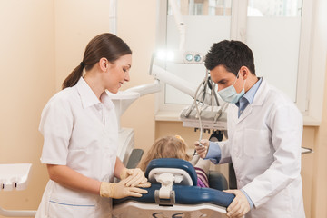 Obraz premium back view of little girl at dentist chair.