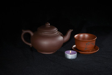 Burning candle with tea ceramic dishware