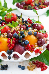 dish with fresh seasonal fruit and berries on table, close-up