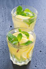 lemonade with mint in glasses on a dark background, vertical