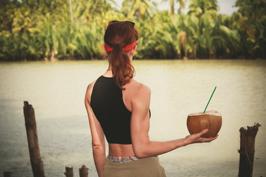 Woman with coconut by a river