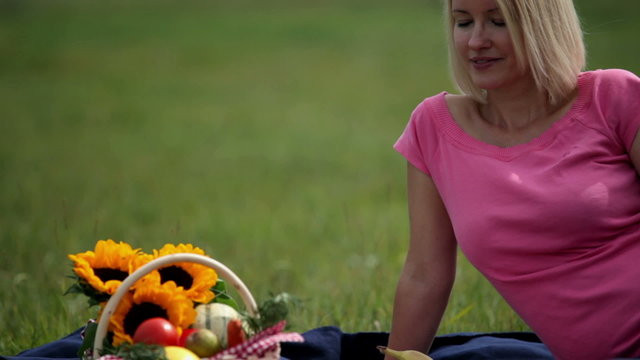 Close shot of woman checking the pinic meal beneath her