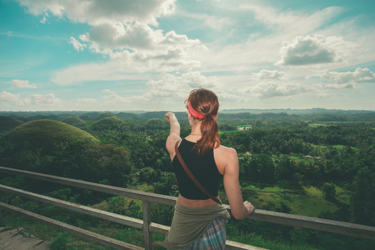 Young woman admiring jungle landscape from top of hill