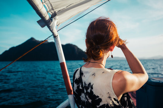 Woman on boat approaching tropical island