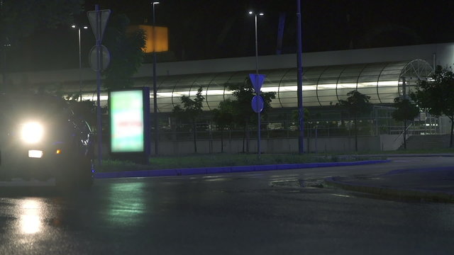 Blue car drives past the camera screen at night