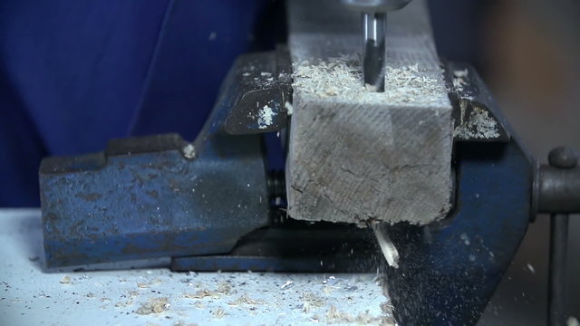 Drilling through wood in workshop
