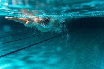 Male swimmer at the swimming pool.Underwater photo.