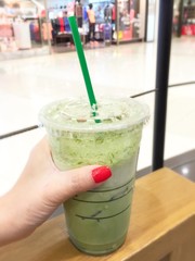 woman in red nails hold ice green tea