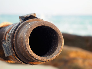 Sewage pipe is rusty and the background is the sea - 77447125