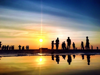 The Silhouettes are Activities on the Beach at Sunset - 77447196