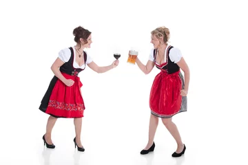 Foto op Canvas Frauen im Dirndl mit Rotwein und Bier stoßen an Porträt © www.freund-foto.de
