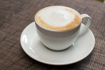 Cup of cappuccino over wooden table