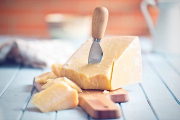 parmesan cheese on cutting board - obrazy, fototapety, plakaty