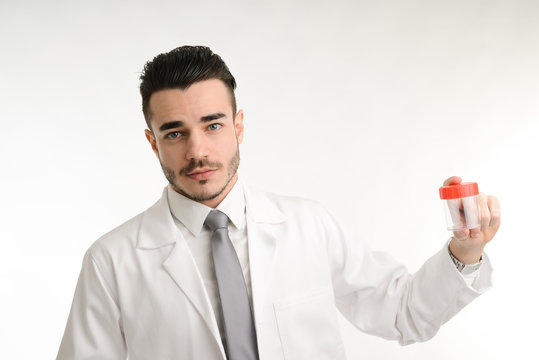 young man chemist on white coat showing bottle of pills