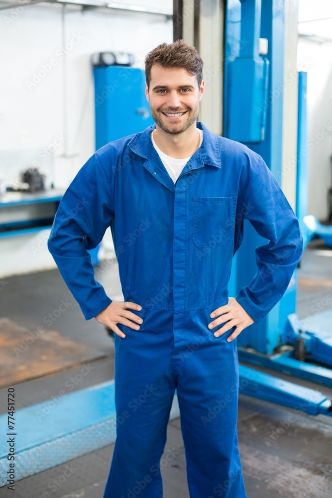 Poster smiling mechanic looking at camera