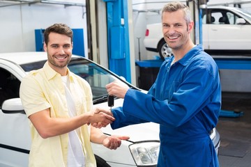 Customer shaking hands with mechanic taking keys