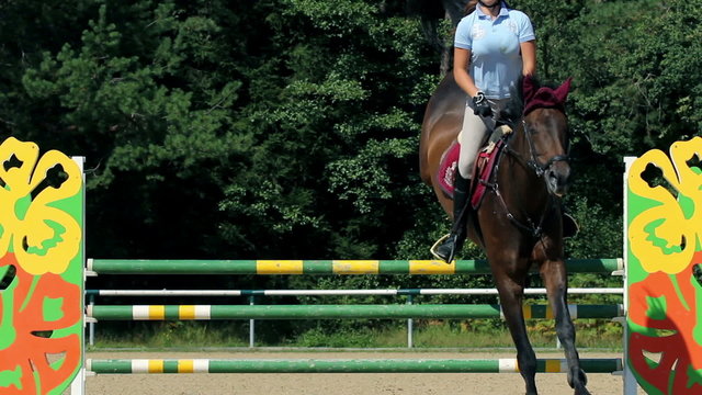 woman jockey jumping over obstacles