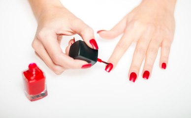 Red manicure nail polish painting nails on bright background