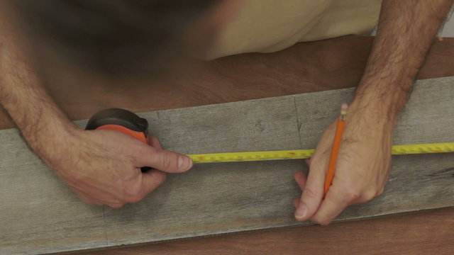 Carpenter Measuring Wood Overhead Close Up