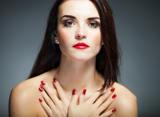 Natural woman face with red nails and lips