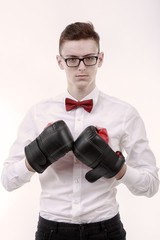 Attractive young caucasian businessman wearing boxing gloves.