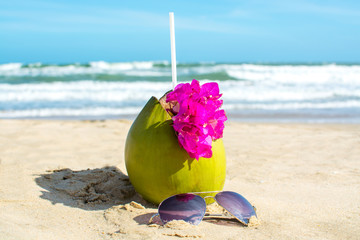 Coconut and sunglasses on the beach
