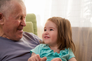 Cute little girl laughing with her grandfather