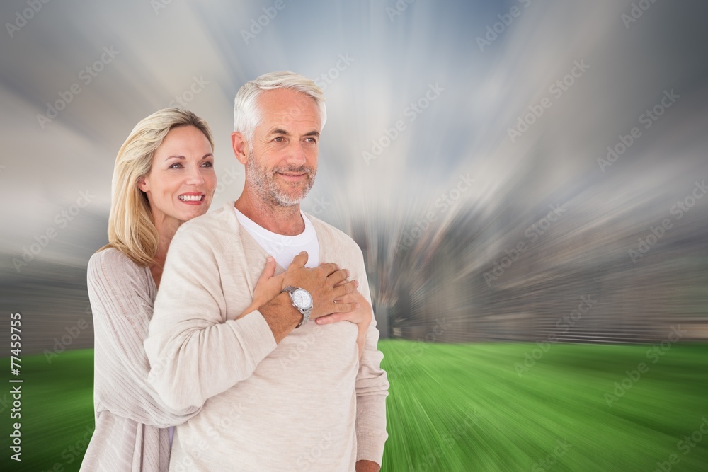 Poster Composite image of happy couple standing and hugging